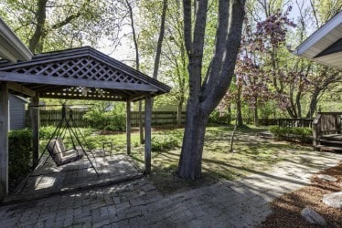 view of home's community featuring a gazebo, fence, a wooden deck, and a patio
