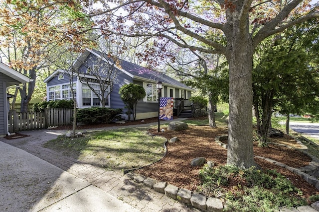 view of front of home with fence and a shingled roof