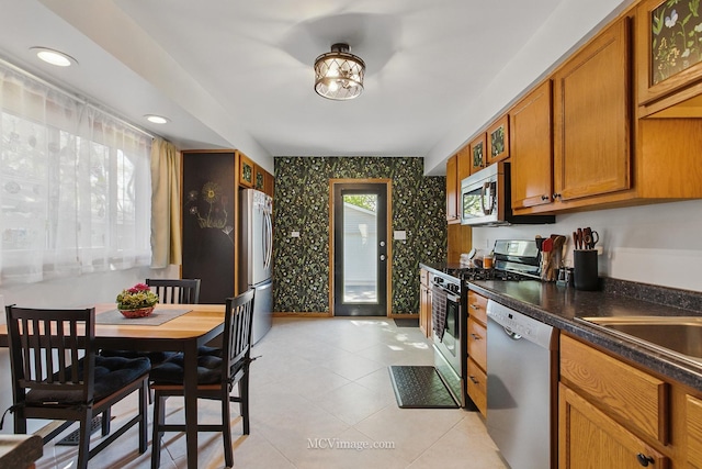 16810 Highview Ave, Orland Hills, IL 60487 - kitchen featuring stainless steel appliances, wallpapered walls, brown cabinets, dark countertops, and light tile patterned floors