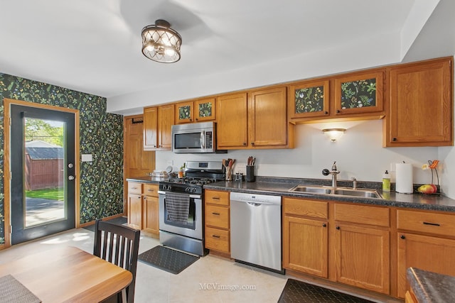 16810 Highview Ave, Orland Hills, IL 60487 - kitchen with stainless steel appliances, wallpapered walls, a sink, brown cabinetry, and glass insert cabinets