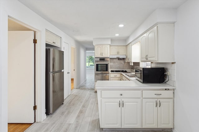 1230 W 112th Pl, Chicago, IL 60643 - kitchen with appliances with stainless steel finishes, under cabinet range hood, a warming drawer, a peninsula, and tasteful backsplash