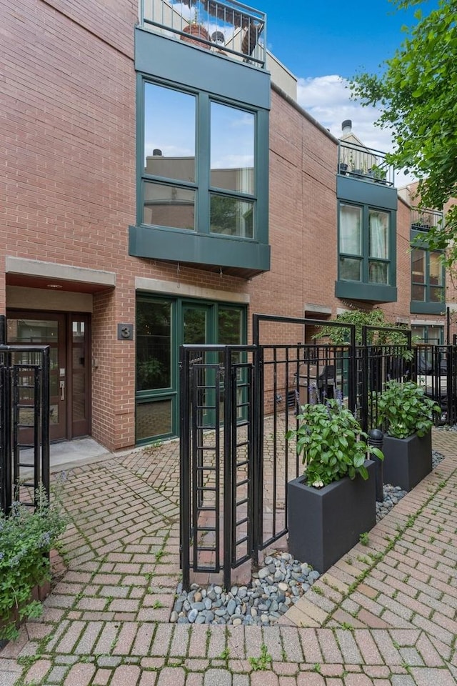 back of house featuring fence and brick siding