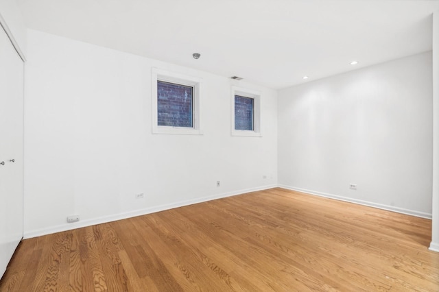 empty room featuring light wood-style flooring, baseboards, and recessed lighting