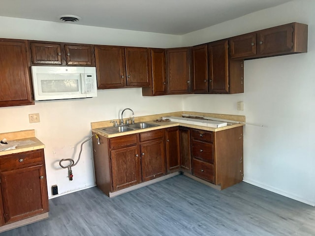 430 Spring Ave, Dekalb, IL 60115 - kitchen featuring white microwave, a sink, wood finished floors, light countertops, and baseboards