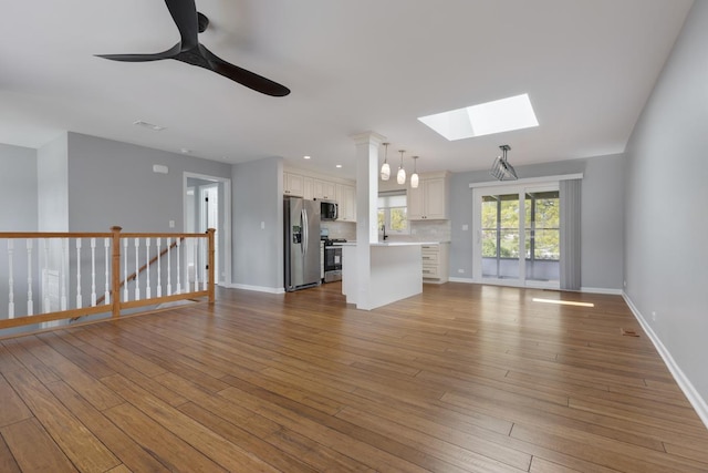 50 Kendal Rd, Elk Grove Village, IL 60007 - unfurnished living room featuring a skylight, a ceiling fan, baseboards, and wood finished floors