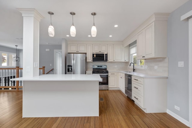 50 Kendal Rd, Elk Grove Village, IL 60007 - kitchen with appliances with stainless steel finishes, backsplash, hardwood / wood-style floors, light countertops, and a sink