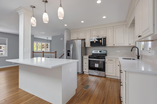 50 Kendal Rd, Elk Grove Village, IL 60007 - kitchen featuring stainless steel appliances, a sink, light wood-type flooring, tasteful backsplash, and white cabinets