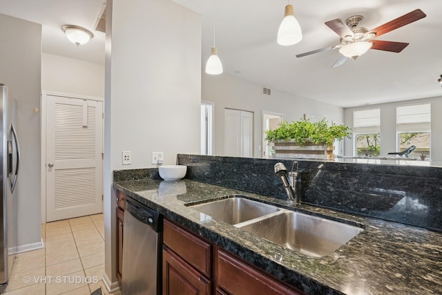 kitchen featuring stainless steel appliances, a sink, light tile patterned floors, a ceiling fan, and decorative light fixtures