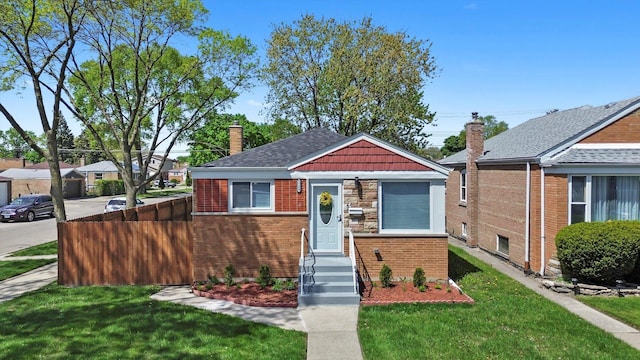 bungalow-style house with a front lawn, a chimney, and brick siding