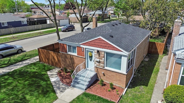 view of front of house with brick siding, a residential view, roof with shingles, and a chimney