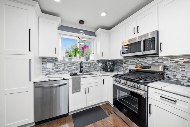 kitchen with appliances with stainless steel finishes, a sink, white cabinetry, tasteful backsplash, and recessed lighting