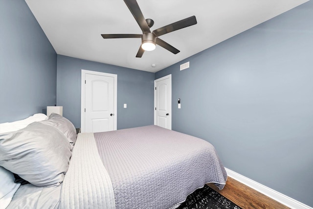 bedroom featuring baseboards, wood finished floors, and ceiling fan