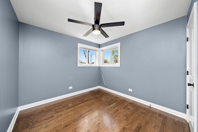 empty room featuring baseboards, ceiling fan, and dark wood finished floors
