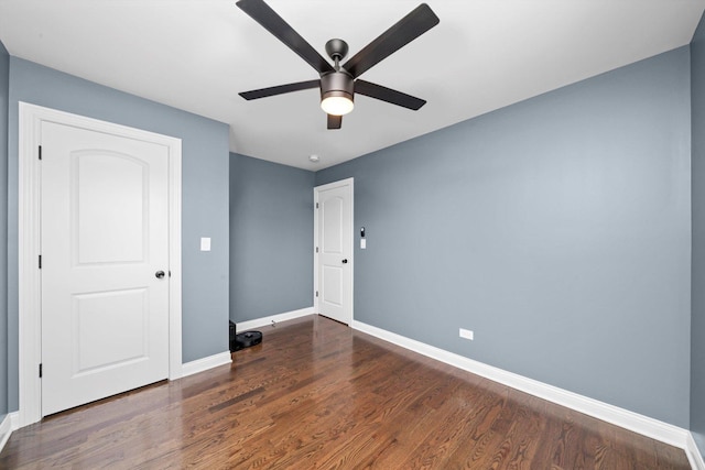 unfurnished bedroom with baseboards, wood finished floors, and ceiling fan