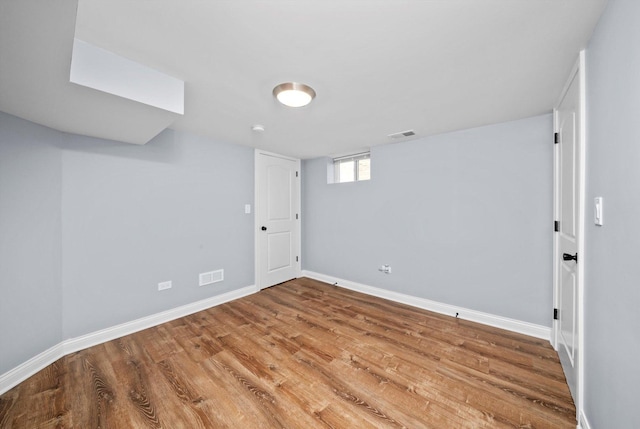 basement featuring baseboards and wood finished floors