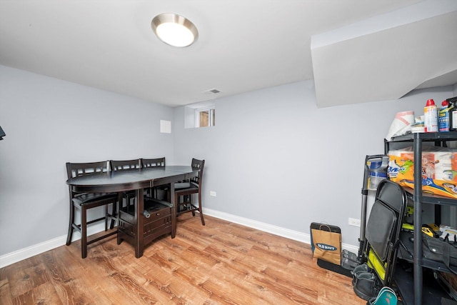 dining area featuring light wood-style flooring and baseboards