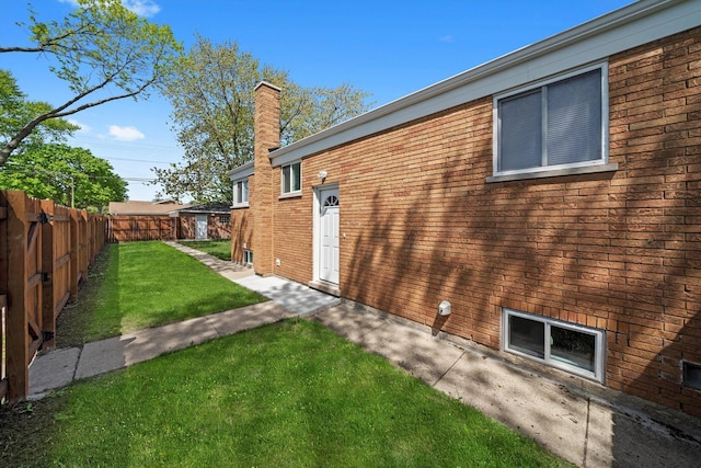view of side of property featuring a chimney and brick siding