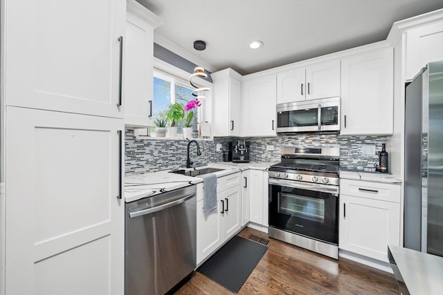 kitchen with appliances with stainless steel finishes, a sink, white cabinets, and recessed lighting