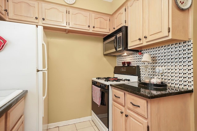 kitchen featuring range with gas cooktop, freestanding refrigerator, decorative backsplash, light tile patterned flooring, and light brown cabinets