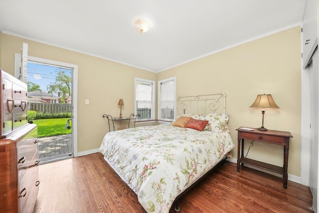 bedroom with access to exterior, multiple windows, wood finished floors, baseboards, and crown molding