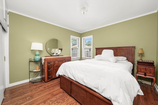 bedroom featuring ornamental molding, wood finished floors, and baseboards