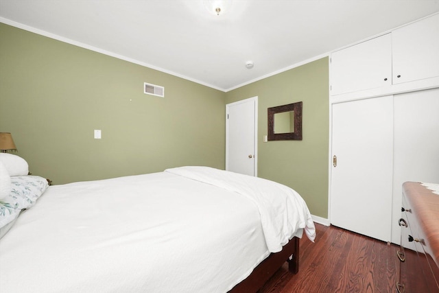 bedroom with ornamental molding, dark wood-style flooring, a closet, and baseboards