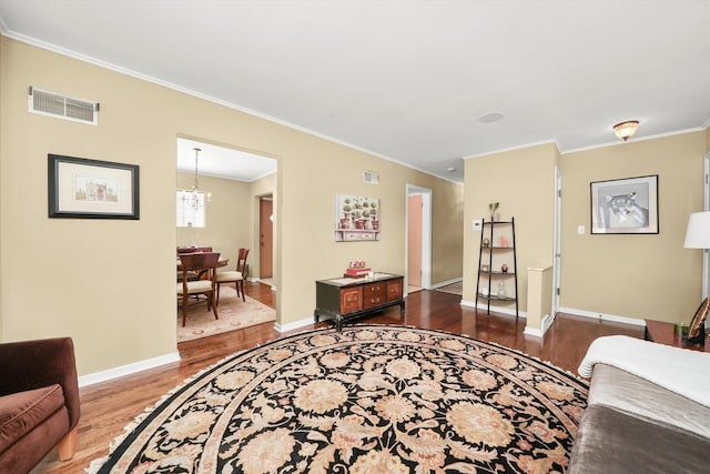 living room featuring dark wood finished floors, crown molding, a chandelier, and baseboards