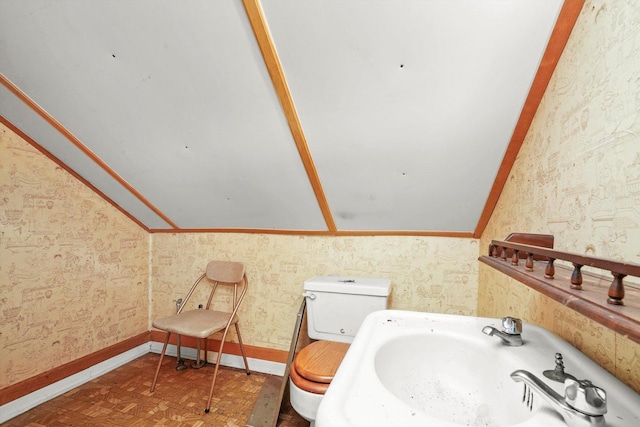 3732 Wisconsin Ave, Berwyn, IL 60402 - bathroom with a sink, toilet, vaulted ceiling, baseboards, and wallpapered walls