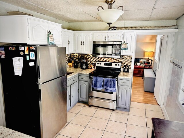 1258 Perry St, Des Plaines, IL 60016 - kitchen with stainless steel appliances, gray cabinets, light tile patterned flooring, white cabinets, and backsplash