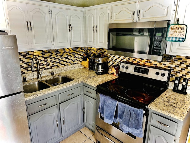 1258 Perry St, Des Plaines, IL 60016 - kitchen featuring appliances with stainless steel finishes, backsplash, gray cabinets, light stone counters, and light tile patterned floors