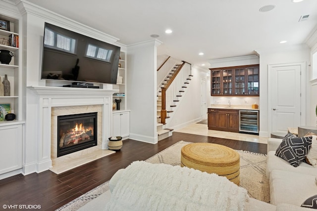 1931 W Barry Ave, Chicago, IL 60657 - living room featuring wine cooler, bar with sink, a premium fireplace, wood finished floors, and ornamental molding
