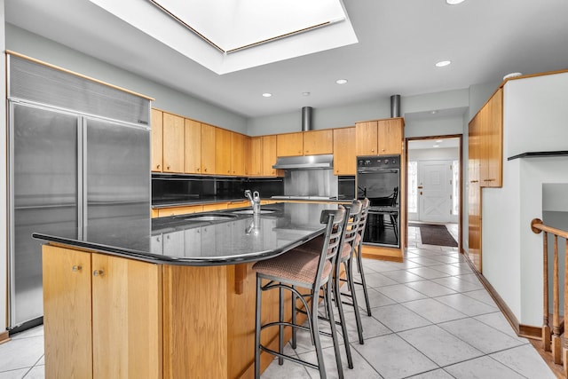 6801 N Lexington Ln, Niles, IL 60714 - kitchen featuring built in fridge, under cabinet range hood, a skylight, light tile patterned floors, and recessed lighting