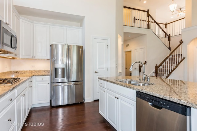 3815 Ridge Pointe Dr, Geneva, IL 60134 - kitchen with appliances with stainless steel finishes, a high ceiling, white cabinetry, dark wood-type flooring, and light stone counters