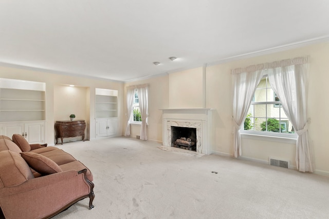 317 Blackhawk Rd, Riverside, IL 60546 - living area featuring a fireplace, carpet flooring, baseboards, built in shelves, and crown molding