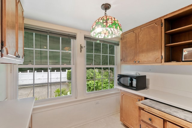 317 Blackhawk Rd, Riverside, IL 60546 - kitchen featuring black microwave, light countertops, open shelves, pendant lighting, and light tile patterned floors