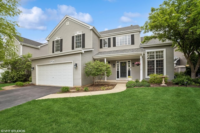 39W326 W Mallory Dr, Geneva, IL 60134 - traditional home featuring asphalt driveway, a garage, a front lawn, a shingled roof, and covered porch