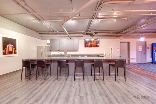 565 W Quincy St Unit 1206, Chicago, IL 60661 - kitchen with freestanding refrigerator, light wood-type flooring, a kitchen breakfast bar, and baseboards