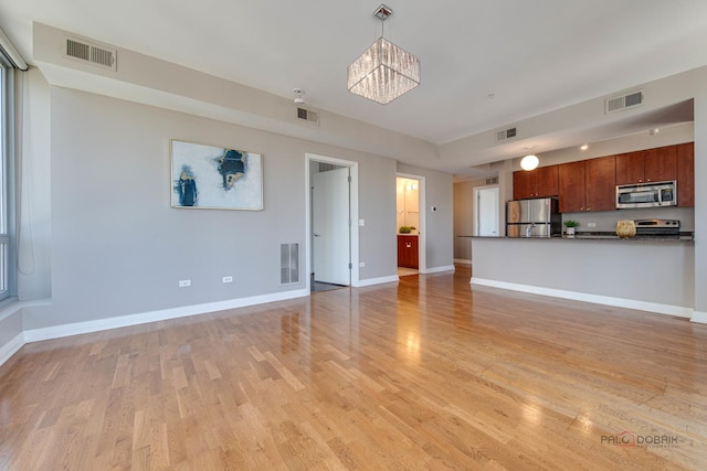 565 W Quincy St Unit 1206, Chicago, IL 60661 - unfurnished living room with a chandelier, light wood-style flooring, and baseboards