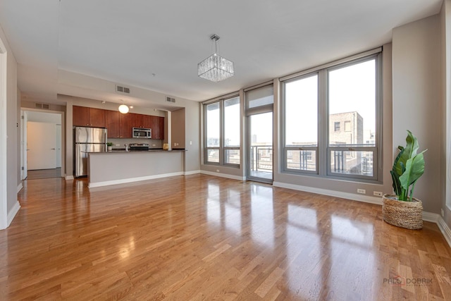 565 W Quincy St Unit 1206, Chicago, IL 60661 - unfurnished living room featuring light wood finished floors, baseboards, and a chandelier