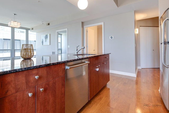 565 W Quincy St Unit 1206, Chicago, IL 60661 - kitchen featuring a sink, appliances with stainless steel finishes, light wood finished floors, dark stone countertops, and baseboards