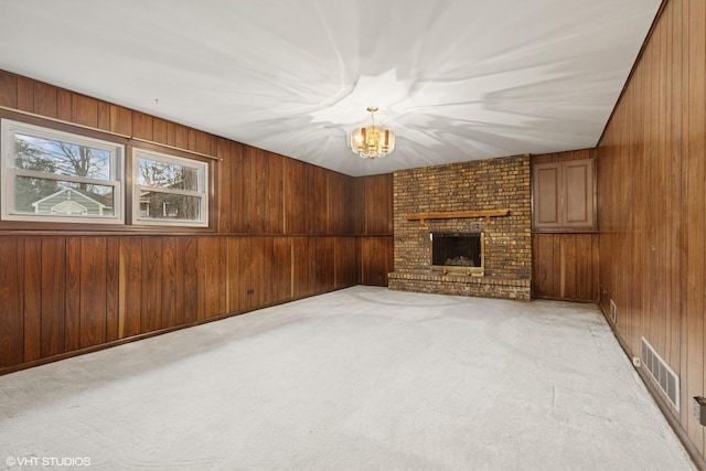 1092 Aberdeen Ln, Mundelein, IL 60060 - unfurnished living room with a chandelier, wood walls, a fireplace, and light colored carpet