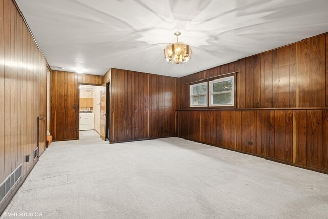 1092 Aberdeen Ln, Mundelein, IL 60060 - empty room with a chandelier, wooden walls, light colored carpet, and washer / dryer