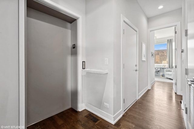 hall featuring dark wood finished floors, elevator, and baseboards