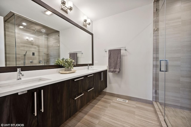 full bathroom with a stall shower, double vanity, and baseboards