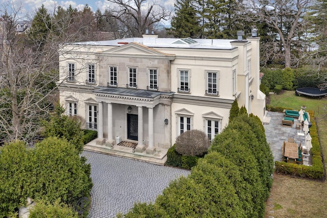 977 Sheridan Rd, Winnetka, IL 60093 - neoclassical home featuring stone siding, a patio, a chimney, and stucco siding