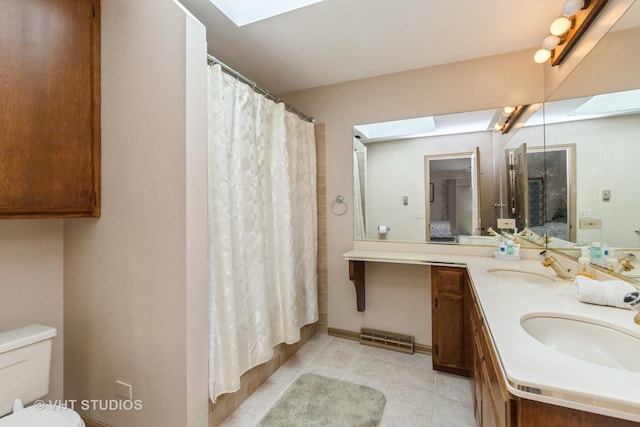38695 N Shagbark Ln, Wadsworth, IL 60083 - full bathroom with connected bathroom, a skylight, double vanity, toilet, and tile patterned floors