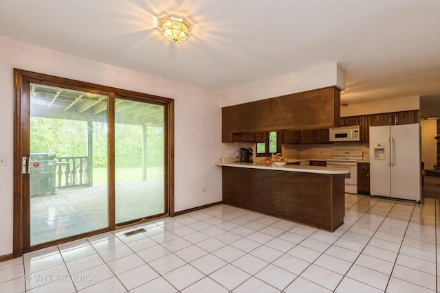 38695 N Shagbark Ln, Wadsworth, IL 60083 - kitchen with white appliances, a peninsula, light countertops, baseboards, and dark brown cabinets