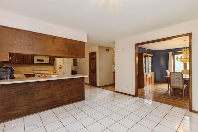 38695 N Shagbark Ln, Wadsworth, IL 60083 - kitchen featuring white appliances, a chandelier, light countertops, a peninsula, and light tile patterned floors