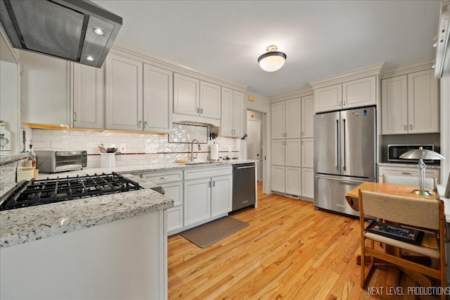 1731 Garfield Ave, Aurora, IL 60506 - kitchen featuring appliances with stainless steel finishes, exhaust hood, a sink, decorative backsplash, and light wood-type flooring