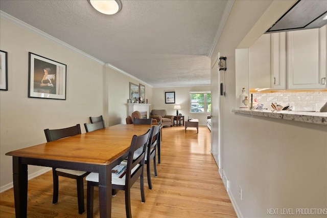 1731 Garfield Ave, Aurora, IL 60506 - dining room with light wood-type flooring, crown molding, a textured ceiling, and baseboards